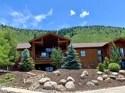 Modern home with boulders, trees and mulch installed by True Blue's landscapers in Durango